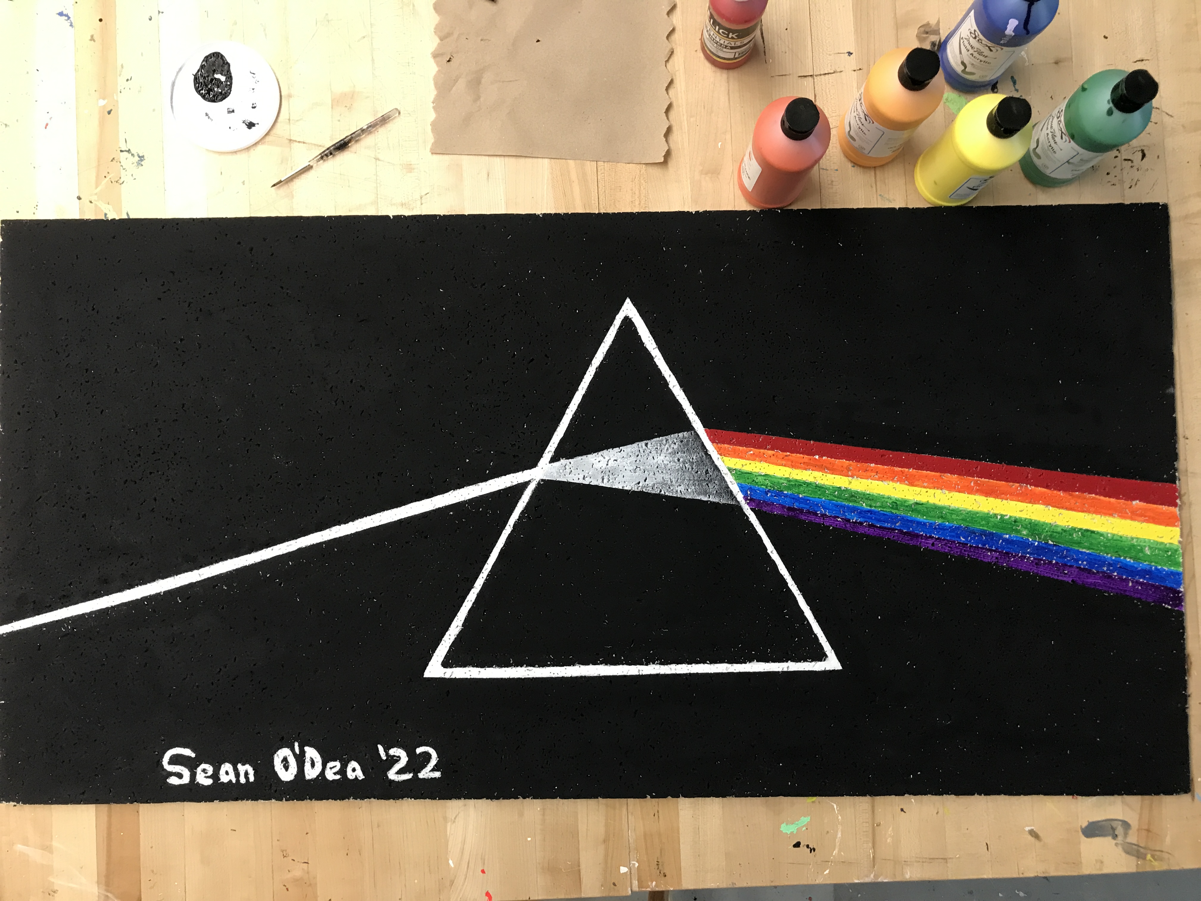 an acrylic painting of the Dark Side of the Moon album cover on a ceiling tile
